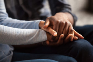 A couple holds hands. They are feeling better since starting online premarital counseling in California with Headway Therapy.