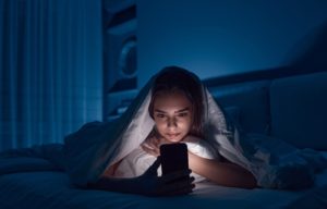 teenager on screens at night